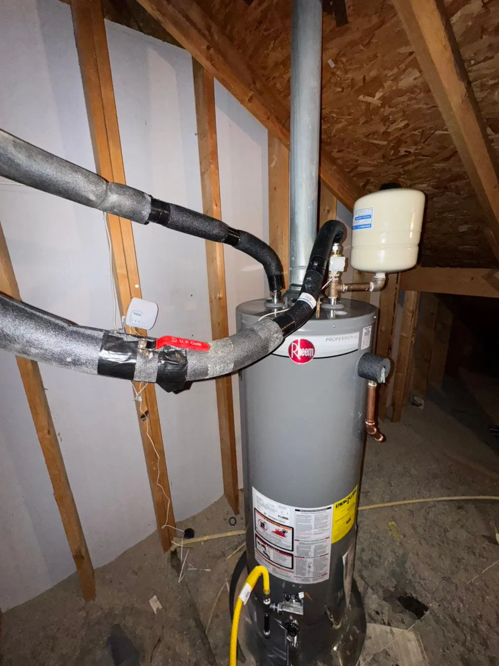 Attic water heater piping with a blue expansion tank